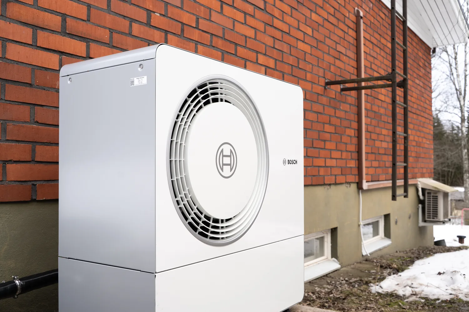 Bosch-lämpöpumpun ulkoyksikkö asennettuna omakotitalon seinustalle